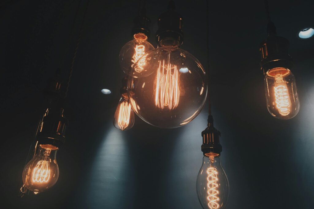 multiple lightbulbs hanging with a dark background